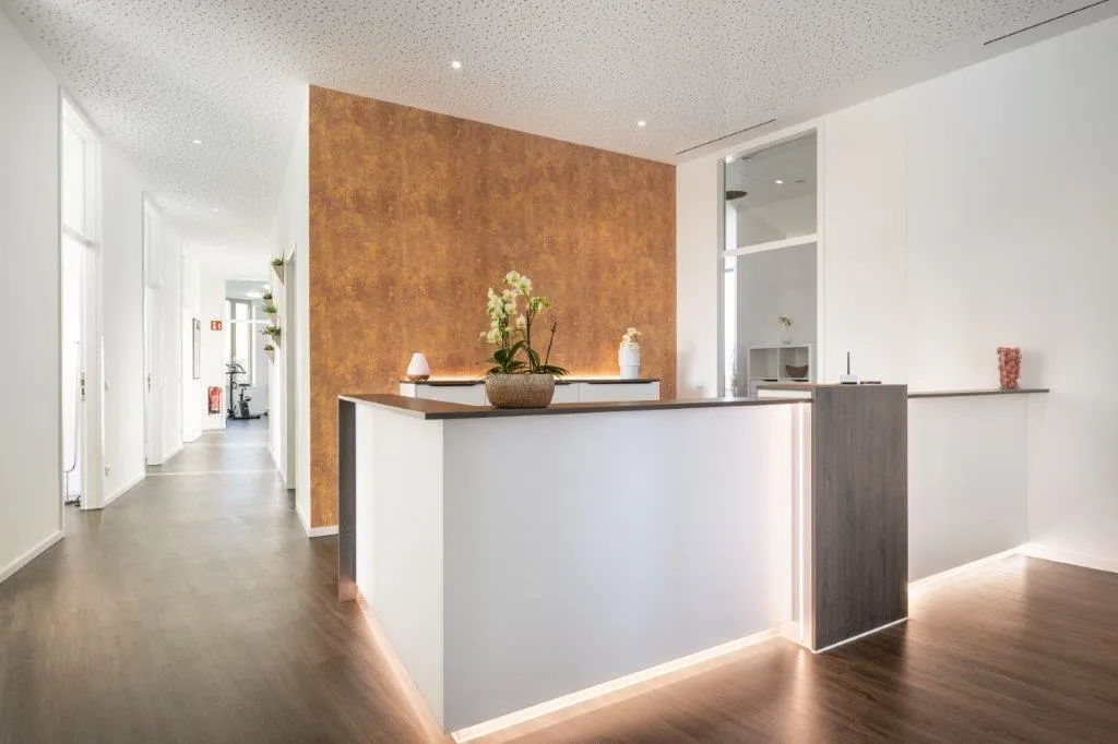 Empfang der Praxis mit heller Theke und Holzwand